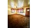 A living room with textured walls, a ceiling fan, a front door and windows with curtains at 204 Long Creek Rd, Bessemer City, NC 28016