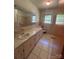 Bathroom with a marbled countertop vanity, tiled floor and walls, window, toilet and a mirror at 215 Suncrest Rd, Cherryville, NC 28021