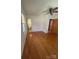 Bedroom featuring gleaming hardwood floors, a ceiling fan, two windows, and access to an ensuite half bath at 215 Suncrest Rd, Cherryville, NC 28021