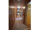 Hallway with wooden paneled walls and carpet flooring that provides access to various rooms within the home at 215 Suncrest Rd, Cherryville, NC 28021