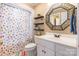 Bathroom view featuring colorful polka dot shower curtain, floating shelves, mirror and white vanity at 2166 Potpourri Pt, Rock Hill, SC 29732