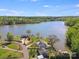 A stunning aerial view showcases a home on a lake with lush trees and a serene atmosphere at 221 River Loop Rd, Belmont, NC 28012