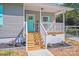 Inviting front porch with teal door, grey siding, white railings, and well-manicured landscaping at 221 River Loop Rd, Belmont, NC 28012