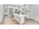 Bright, modern kitchen with stainless steel appliances, white cabinets, an island, and hardwood floors at 221 River Loop Rd, Belmont, NC 28012