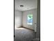 Cozy bedroom with plush carpeting and a window overlooking a blue house at 2231 Catawba Trace Dr, Catawba, NC 28609