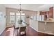 Bright dining area with hardwood floors and modern lighting fixture, adjacent to the kitchen at 2268 Kensington Station Pkwy, Charlotte, NC 28210