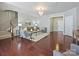 Bright living room featuring hardwood floors, neutral paint, a crystal chandelier, and an open floor plan at 2268 Kensington Station Pkwy, Charlotte, NC 28210