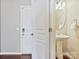 A neutral colored powder room with open door to the outside entrance of the home at 2268 Kensington Station Pkwy, Charlotte, NC 28210