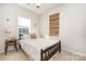 Bright bedroom with a detailed wood frame bed, neutral walls, and carpet at 2410 Dr Carver Rd, Charlotte, NC 28208