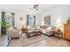 Inviting living room boasts natural light, ceiling fan, a cozy sectional, area rug, and hardwood floors at 2410 Dr Carver Rd, Charlotte, NC 28208