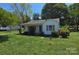 Charming home features a covered porch, green lawn and landscape, and light colored exterior at 2607 Lowell Rd, Gastonia, NC 28054