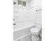 Bright bathroom featuring a shower-tub combination and modern toilet, complete with shelving at 2616 Holton Ave, Charlotte, NC 28208