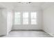 Bright bedroom featuring three windows for ample natural light and modern, gray vinyl flooring at 2616 Holton Ave, Charlotte, NC 28208