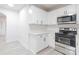 Well-lit kitchen features stainless steel appliances, white cabinets, and stylish countertops at 2616 Holton Ave, Charlotte, NC 28208