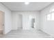 Spacious living area with archways, new gray floors, and bright lighting leading to the kitchen with stainless appliances at 2616 Holton Ave, Charlotte, NC 28208