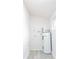 Clean utility room featuring white walls, vinyl flooring and a modern water heater at 2616 Holton Ave, Charlotte, NC 28208