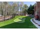 Backyard features a putting green, wooden deck with hot tub, and dark metal fencing at 3010 Lakewood Edge Dr, Charlotte, NC 28269