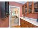 Butlers Pantry featuring hardwood cabinetry, counterspace with sink, and glass shelving at 3010 Lakewood Edge Dr, Charlotte, NC 28269