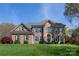 Stunning brick two-story home with manicured lawn and blue shutters on a sunny day at 3010 Lakewood Edge Dr, Charlotte, NC 28269