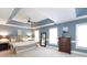 Spacious primary bedroom featuring a tray ceiling, ceiling fan, and large windows at 3010 Lakewood Edge Dr, Charlotte, NC 28269