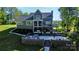 Back of the house featuring a large patio, deck, and a manicured lawn with a wooded perimeter at 3915 Chevlot Hills Rd, Sherrills Ford, NC 28673