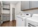 Well-equipped laundry room features modern washer, dryer, cabinets, granite counters, and hardwood floors at 3915 Chevlot Hills Rd, Sherrills Ford, NC 28673