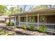 Inviting brick home featuring a charming front porch with white picket fence and lush landscaping at 4067 Old Buff Rd, Hickory, NC 28602