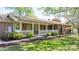 Charming brick home with a covered front porch and white picket fence surrounded by green lawn at 4067 Old Buff Rd, Hickory, NC 28602