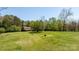 Expansive green yard with a home in the distance, surrounded by mature trees at 4067 Old Buff Rd, Hickory, NC 28602