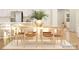 Bright dining room with a long wooden table, neutral chairs, and bar stools overlooking the kitchen at 4194 Skyboat Cir, Fort Mill, SC 29715