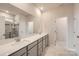 Bathroom featuring double sinks, white countertops, framed mirrors, and a glass-enclosed shower at 4222 Skyboat Cir, Fort Mill, SC 29715