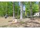 Backyard area featuring tire swing and wooden swing set surrounded by mature trees at 4436 Shiloh Unity Rd, Lancaster, SC 29720