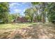 Large backyard with a red brick home, shed, garden, and mature trees at 45 Mckinnon Ne Ave, Concord, NC 28025