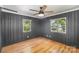 This bedroom features dark walls, windows with tree views, hardwood floors, and a ceiling fan at 45 Mckinnon Ne Ave, Concord, NC 28025