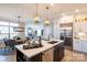 Open-concept kitchen featuring white cabinetry, stainless steel appliances, a large island, and barstool seating at 4825 Reason Ct # 73, Harrisburg, NC 28075