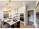 Gourmet kitchen featuring white cabinetry, stainless steel appliances, a marble backsplash, and an expansive island with bar seating at 4825 Reason Ct # 73, Harrisburg, NC 28075