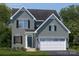Charming two-story home with gray siding, black shutters, a two-car garage, and well-manicured landscaping at 499 Kenyon Dr, Denver, NC 28037