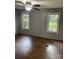 Bedroom featuring hard wood flooring, paneled walls, ceiling fan with lighting, and two windows at 5029 E Nc 10 Hwy Rd # 6, Catawba, NC 28609