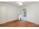 Bright bedroom has hardwood flooring and glass panel door with access to the outside at 516 Northgate Ave, Charlotte, NC 28209