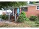 Quaint brick home with a covered porch, turquoise door and landscaped yard at 516 Northgate Ave, Charlotte, NC 28209