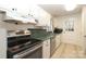 Traditional kitchen features white cabinets, green countertops, and stainless steel appliances at 516 Northgate Ave, Charlotte, NC 28209