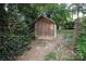 Exterior shot of a weathered wooden shed in a wooded backyard at 516 Northgate Ave, Charlotte, NC 28209