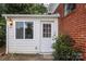 View of side entrance with white door, window, and light fixture at 516 Northgate Ave, Charlotte, NC 28209