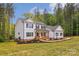 Elegant two-story home featuring manicured lawn and lush greenery, set against a backdrop of mature trees at 545 Morrison Farm Rd, Troutman, NC 28166