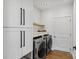 Bright laundry room with modern appliances, white cabinets, and quartz folding counter at 545 Morrison Farm Rd, Troutman, NC 28166