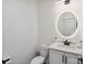 Modern powder room features a round mirror, dark fixtures, and sleek white vanity at 545 Morrison Farm Rd, Troutman, NC 28166