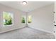 Bright bedroom featuring plush carpeting, fresh neutral paint, and sun-filled windows with outside views at 551 Belfast Dr, Gastonia, NC 28052