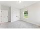Carpeted bedroom features a closet with double doors and a bright window at 551 Belfast Dr, Gastonia, NC 28052