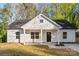 Charming white home featuring a black roof, inviting front porch, and well-manicured lawn at 551 Belfast Dr, Gastonia, NC 28052