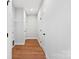 Wood-look flooring extends along a hallway with white walls and doors and wire shelving for storage at 551 Belfast Dr, Gastonia, NC 28052